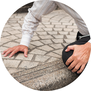 A man kneels on the ground, his hand touching the surface